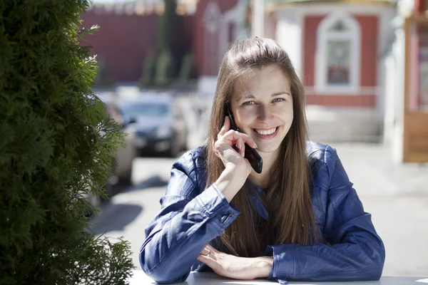Jovem mulher feliz chamando por telefone na rua — Fotografia de Stock