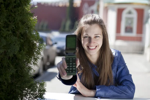Mladá šťastná žena volá po telefonu na ulici — Stock fotografie