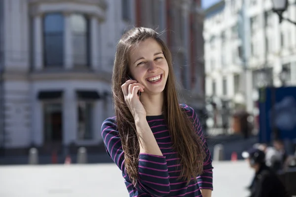 Młoda kobieta szczęśliwa, rozmowa przez telefon na ulicy — Zdjęcie stockowe