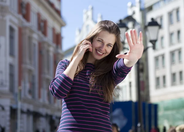 Young happy woman calling by phone on the street — Stock Photo, Image