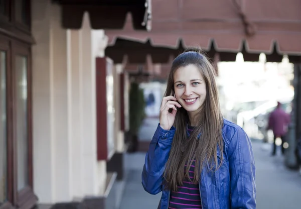 Jovem mulher feliz chamando por telefone na rua — Fotografia de Stock