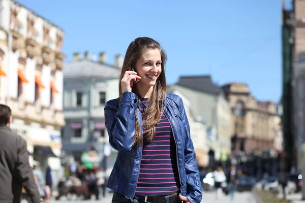 Gelukkig jongedame vragen per telefoon op straat — Stockfoto