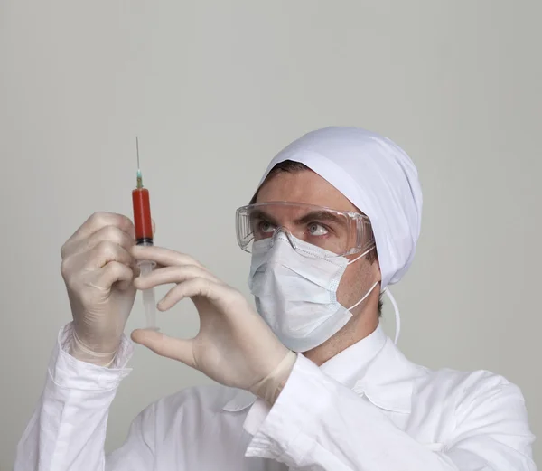 Cirurgião confiante segurando uma seringa — Fotografia de Stock