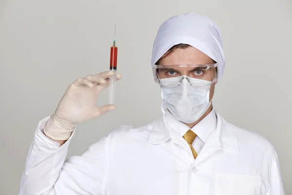 Säker kirurg innehar en spruta — Stockfoto