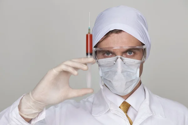 Confident surgeon holding a syringe — Stock Photo, Image