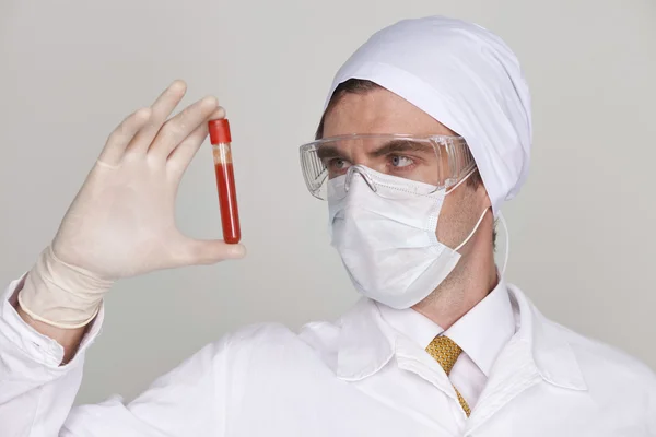 Doutor segurando um copo de sangue — Fotografia de Stock