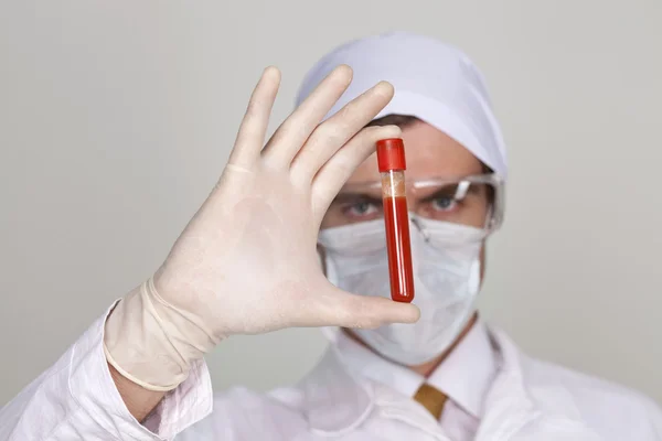 Doutor segurando um copo de sangue — Fotografia de Stock