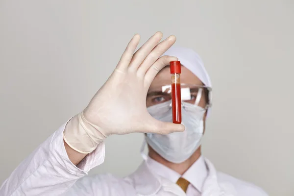 Doutor segurando um copo de sangue — Fotografia de Stock