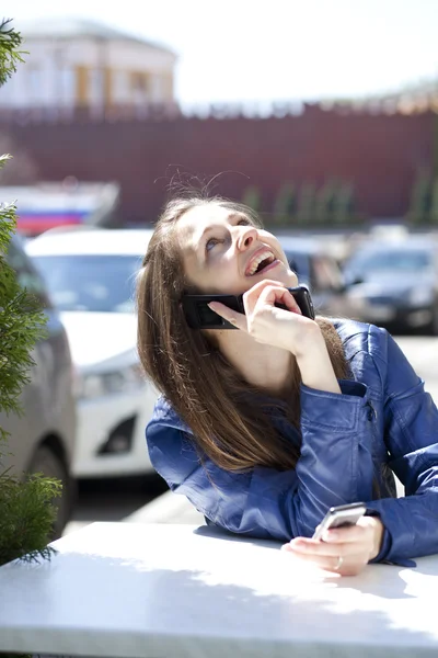 Jovem mulher feliz chamando por telefone na rua — Fotografia de Stock