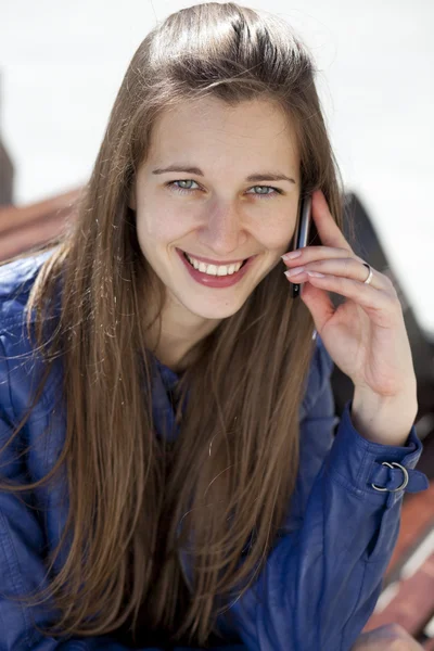 Gelukkig jongedame vragen per telefoon op straat — Stockfoto