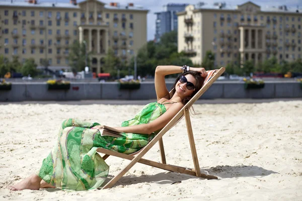 Young beautiful woman relaxing lying on a sun lounger — Stock Photo, Image