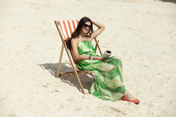 Young beautiful woman relaxing lying on a sun lounger — Stock Photo, Image