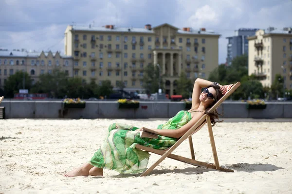 Young beautiful woman relaxing lying on a sun lounger — Stock Photo, Image