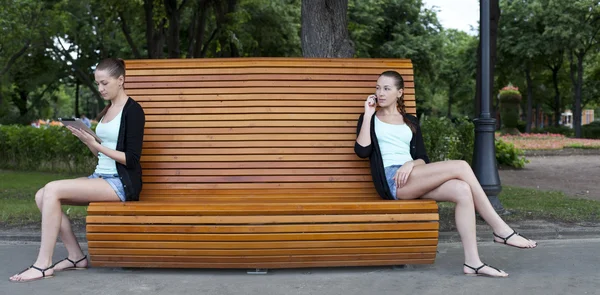 Giovani donne su una panchina del parco estivo — Foto Stock