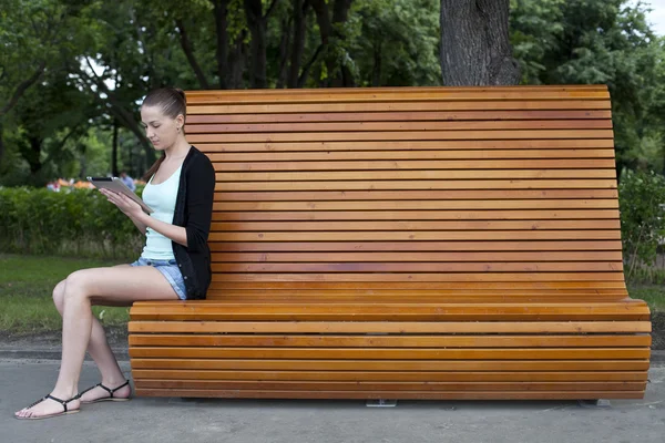 젊은 여자는 공원에 태블릿 컴퓨터를 사용 하 여 — 스톡 사진