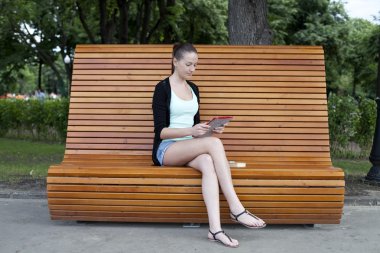 genç kadın bir parkın bir tablet bilgisayar kullanma