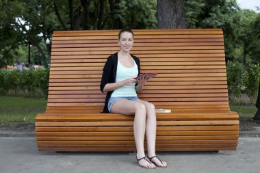 genç kadın bir parkın bir tablet bilgisayar kullanma