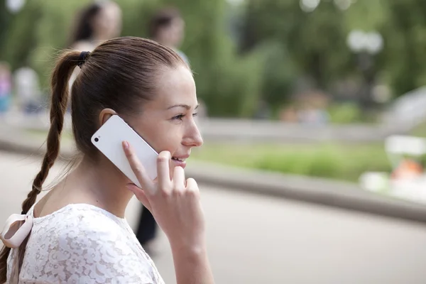 Wanita muda yang bahagia menelepon melalui telepon di jalan — Stok Foto