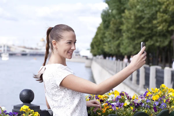 Счастливая молодая женщина фотографирует на телефон — стоковое фото