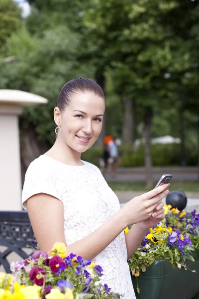 Jonge vrouw leest een bericht aan de telefoon — Stockfoto