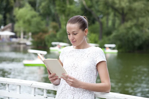Brunette reading book in a summer park — Stock Photo, Image