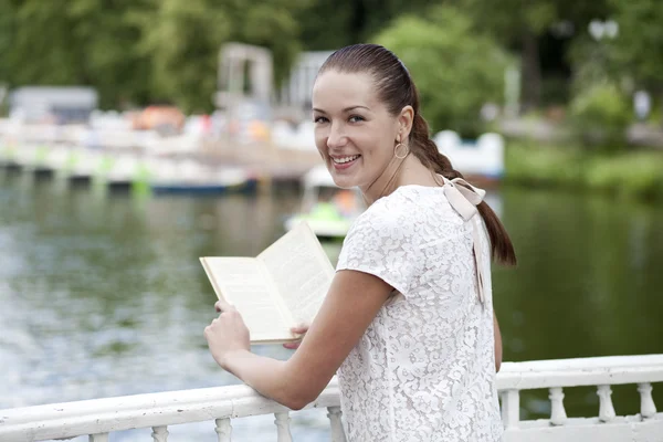 Brünette liest Buch im Sommerpark — Stockfoto