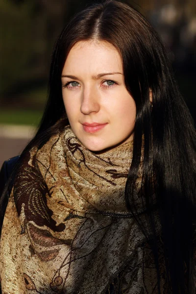 Beautiful brunette woman with golden autumn leaf — Stock Photo, Image