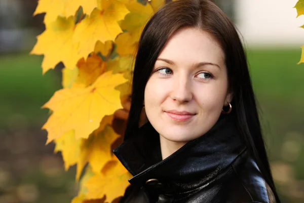 Beautiful brunette woman with golden autumn leaf — Stock Photo, Image
