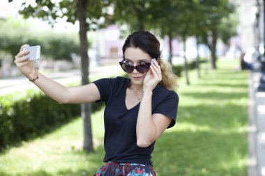 telefonunuzda fotoğraf çekmeye mutlu bir genç kadın