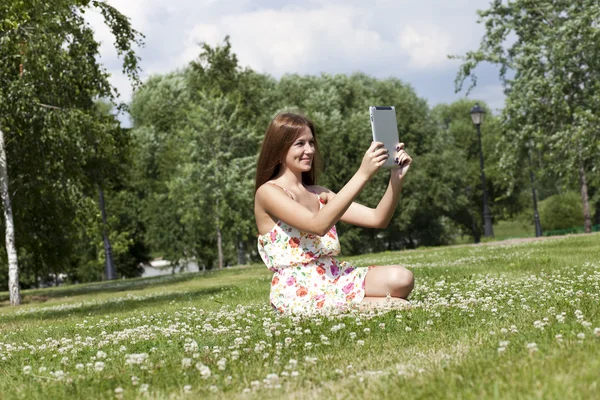 緑の芝生の上に座っている若い女性の肖像画 — ストック写真