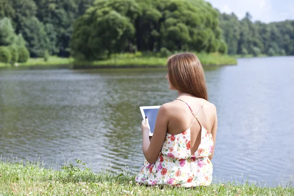 緑の芝生の上に座っている若い女性の肖像画 — ストック写真