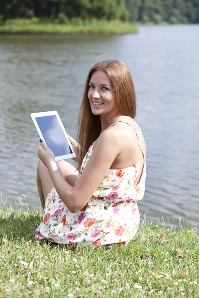 Portrait of young woman sitting on a green lawn — Stock Photo, Image