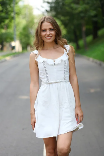 Mooie jonge vrouw lopen op de zomer park — Stockfoto