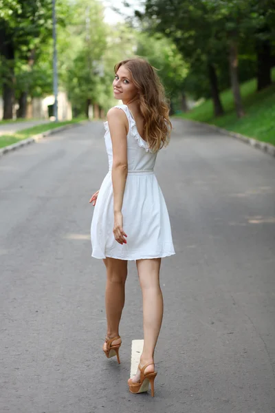 Bella giovane donna che cammina sul parco estivo — Foto Stock