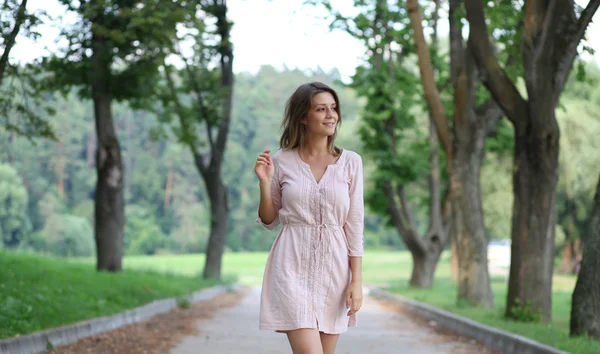 Schöne junge Frau zu Fuß auf dem Sommerpark — Stockfoto