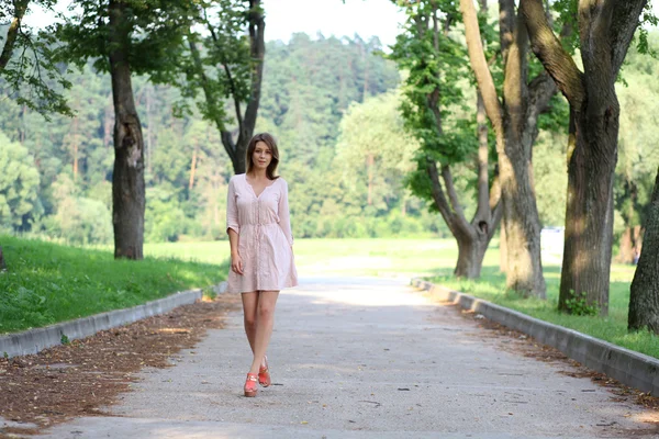 Bella giovane donna che cammina sul parco estivo — Foto Stock