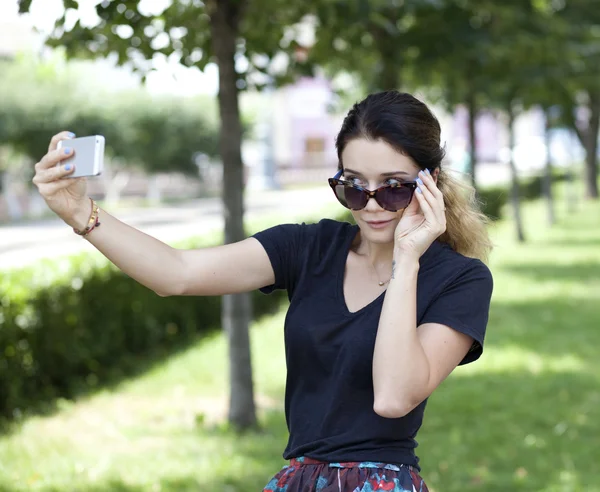 Mujer joven feliz tomando fotos en su teléfono —  Fotos de Stock