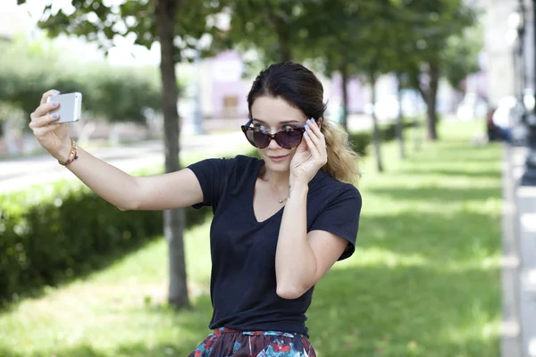 Счастливая молодая женщина фотографирует на телефон — стоковое фото