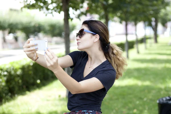 Mujer joven feliz tomando fotos en su teléfono —  Fotos de Stock