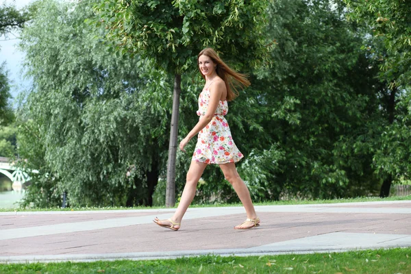 Bella giovane donna che cammina sul parco estivo — Foto Stock