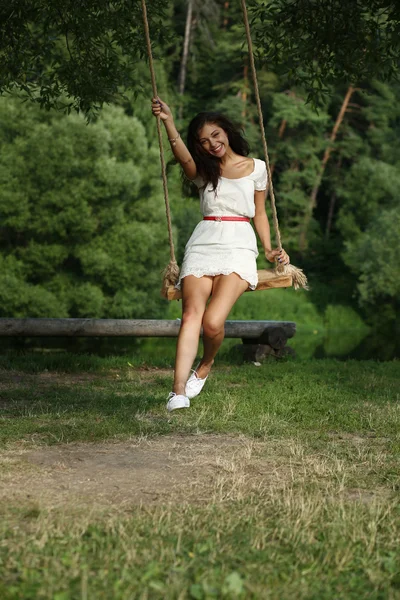 Щаслива жінка катається на гойдалці в парку — стокове фото