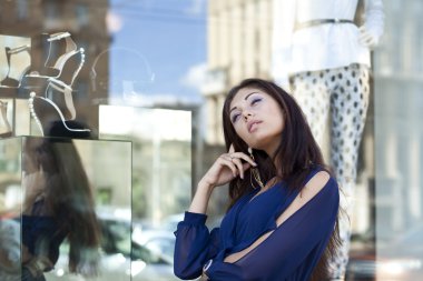 Young woman looking at shop window boutique