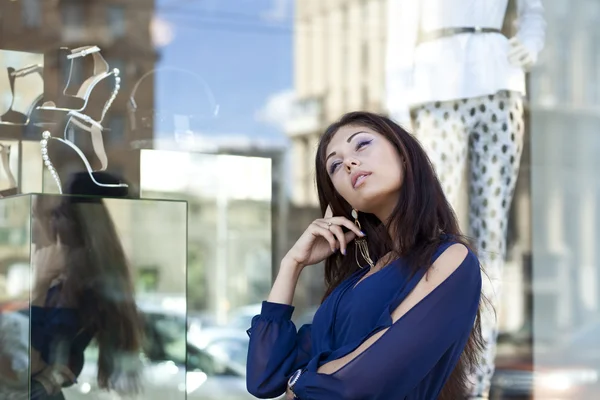 Mladá žena při pohledu na okno butik — Stock fotografie