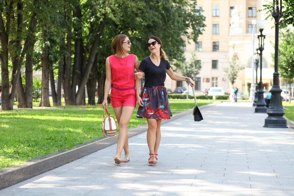 Two young women walking in the summer city — Stock Photo, Image