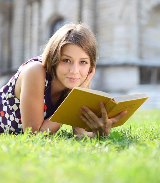 Jovem menina bonita lendo um livro ao ar livre — Fotografia de Stock