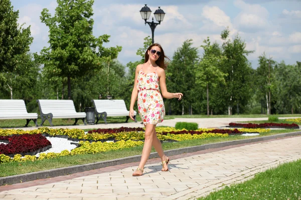 Beautiful young woman walking on the summer park — Stock Photo, Image