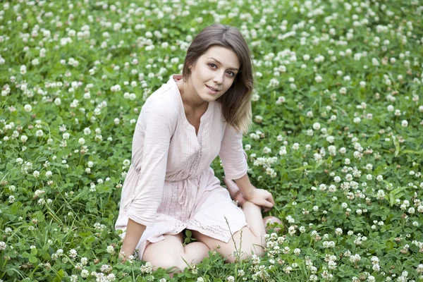 Porträt einer jungen Frau auf einem grünen Rasen — Stockfoto