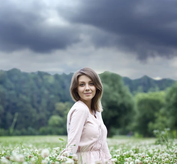 Yeşil çimenlerin üzerinde oturan genç kadın portresi — Stok fotoğraf