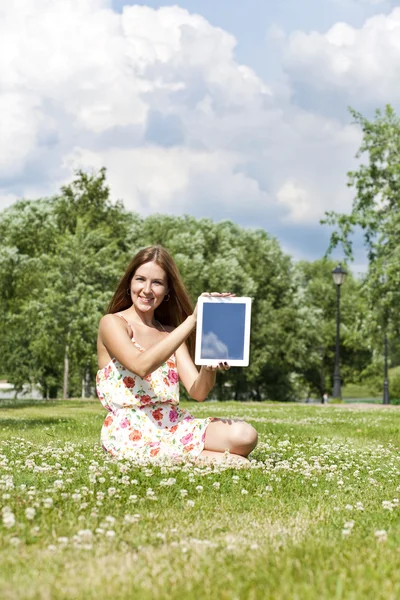 緑の芝生の上に座っている若い女性の肖像画 — ストック写真