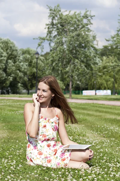 Junge Frau liegt mit Handy in der Hand im Gras — Stockfoto